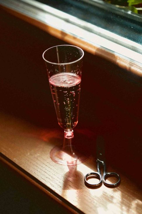 Flûte di rosè frizzante e forbici di design su legno ad Arabba, fotografo matrimonio Arabba Livinallongo.