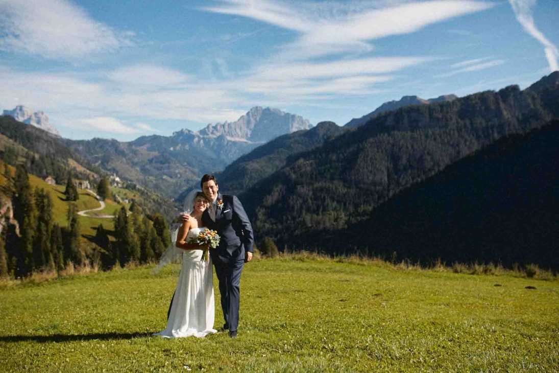 Sposi in un prato alpino con vista sul Monte Civetta, servizio del fotografo matrimonio Arabba - dolomiti.