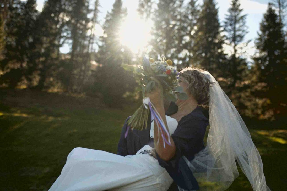 Sposo solleva la sposa al tramonto tra i boschi, servizio del fotografo matrimonio Arabba - dolomiti.