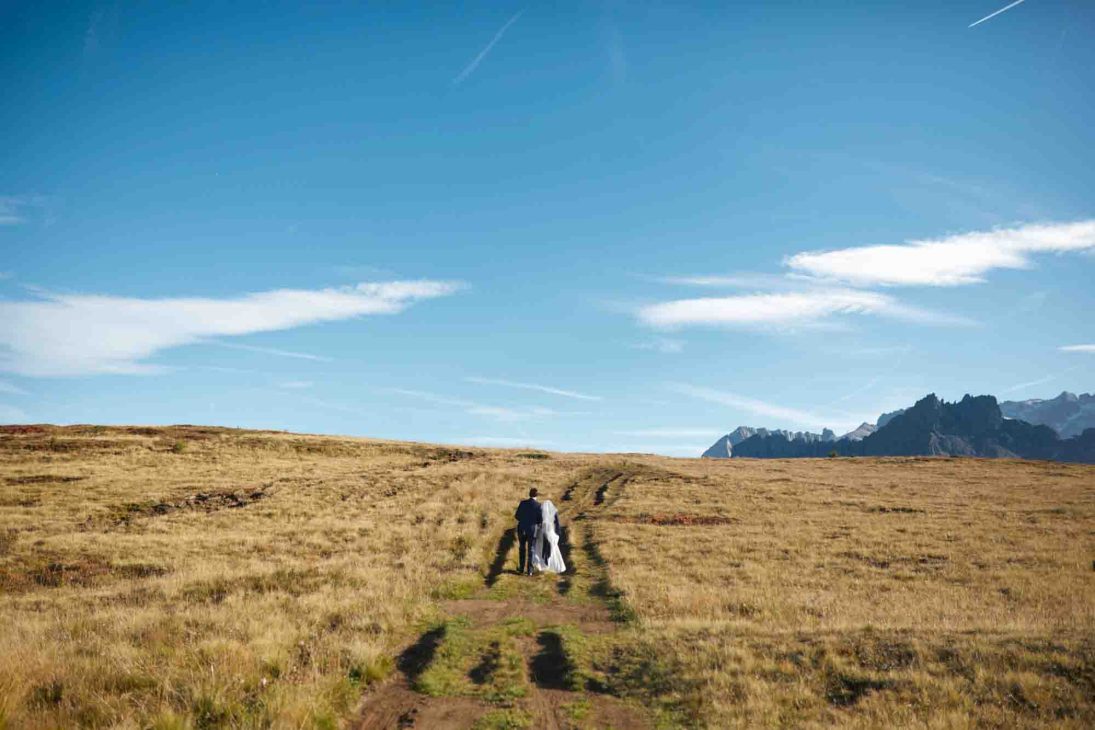 Sposi camminano su un sentiero d'alta quota ad Arabba, servizio del fotografo matrimonio Arabba - dolomiti.