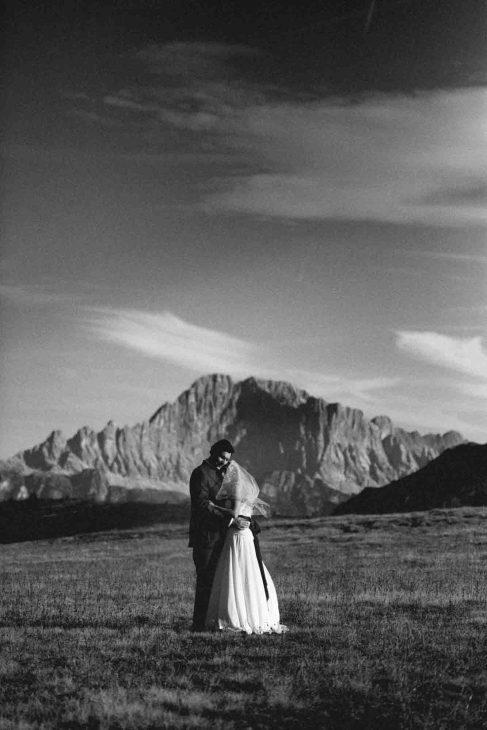 Sposi abbracciati in bianco e nero con sfondo Monte Civetta, servizio del fotografo matrimonio Arabba - dolomiti.
