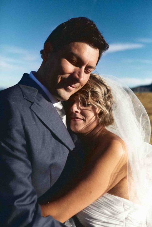 Primo piano sposi abbracciati sotto il sole delle Dolomiti, servizio fotografo matrimonio Arabba - dolomiti.