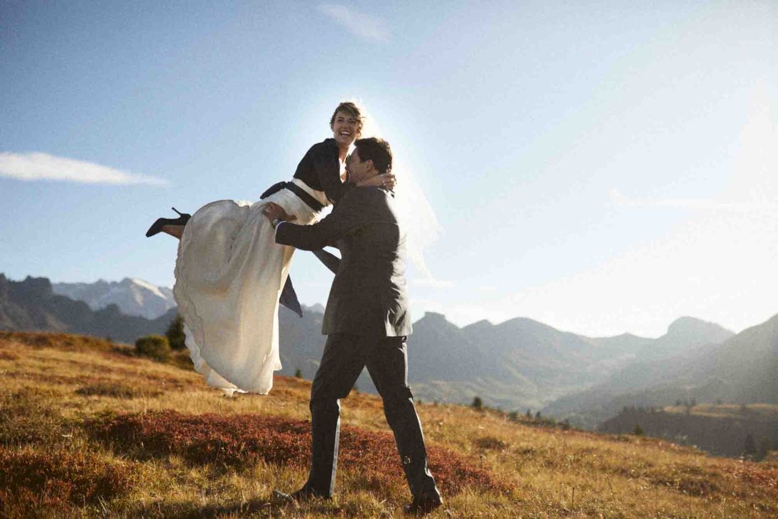 Sposo solleva con gioia la sposa al tramonto ad alta quota, servizio del fotografo matrimonio Arabba - dolomiti.