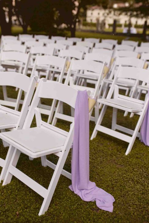 Sedie bianche per cerimonia all'aperto con drappo lilla. Scatto di un fotografo matrimonio villa veneta Vicenza.