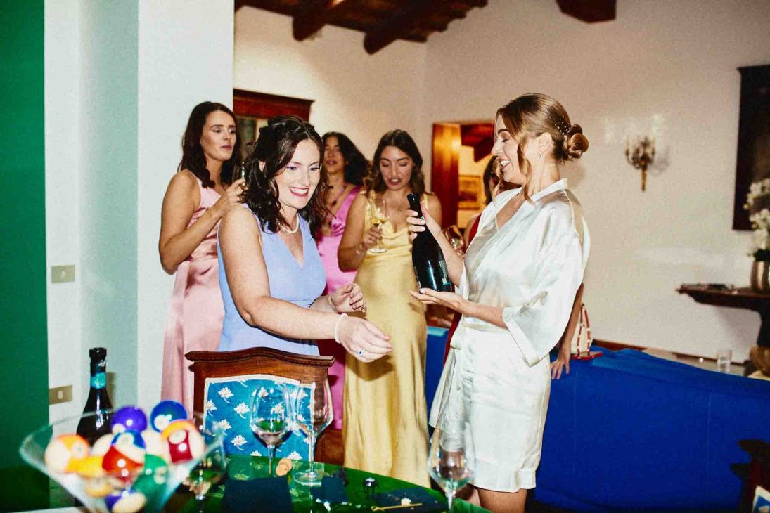 Sposa e damigelle condividono un brindisi spontaneo, catturate da un fotografo matrimonio villa veneta Vicenza.