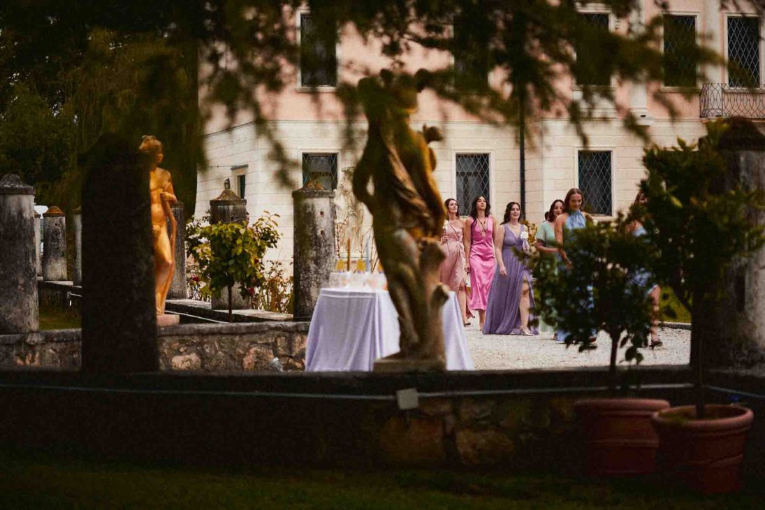 Damigelle in abiti eleganti sfilano nel giardino per il fotografo matrimonio villa veneta Vicenza.