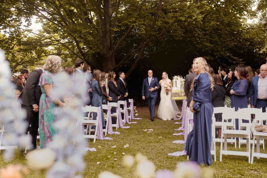 L'ingresso della sposa al braccio del padre nel parco, scatto di fotografo matrimonio villa veneta Vicenza.
