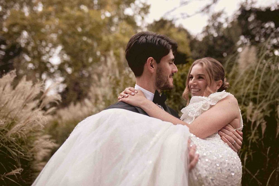 Sposo solleva la sposa tra le braccia nel parco della tenuta, scatto di fotografo matrimonio villa veneta Vicenza.