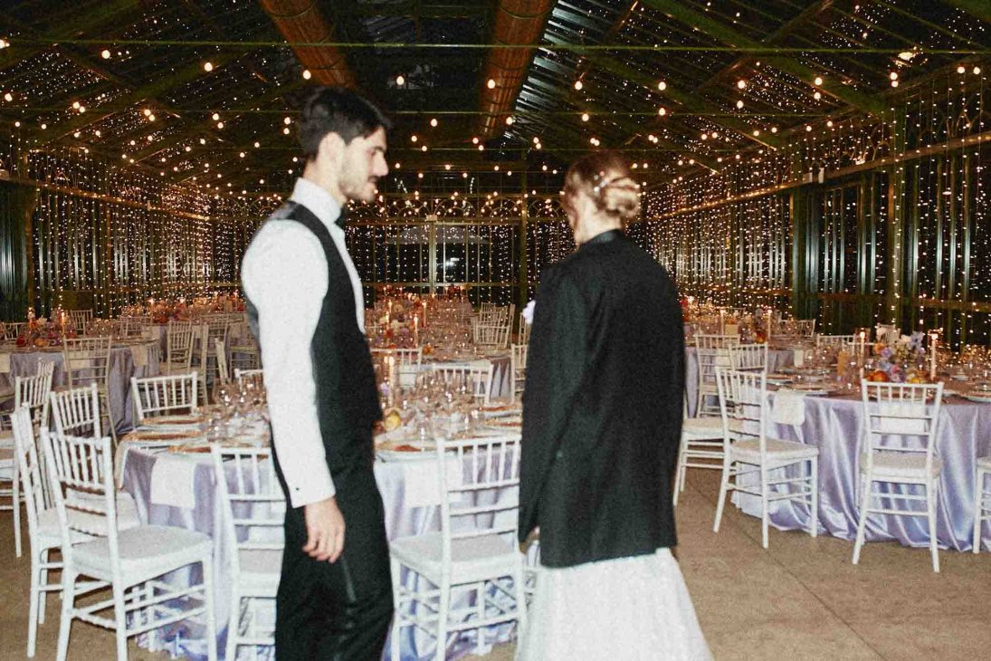Sposi ammirano la sala del banchetto illuminata, scatto di fotografo matrimonio villa veneta Vicenza.