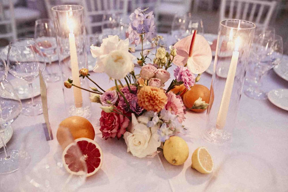 Dettaglio centrotavola fiorito con agrumi e candele accese per un ricevimento a cura di un fotografo matrimonio villa veneta Vicenza.