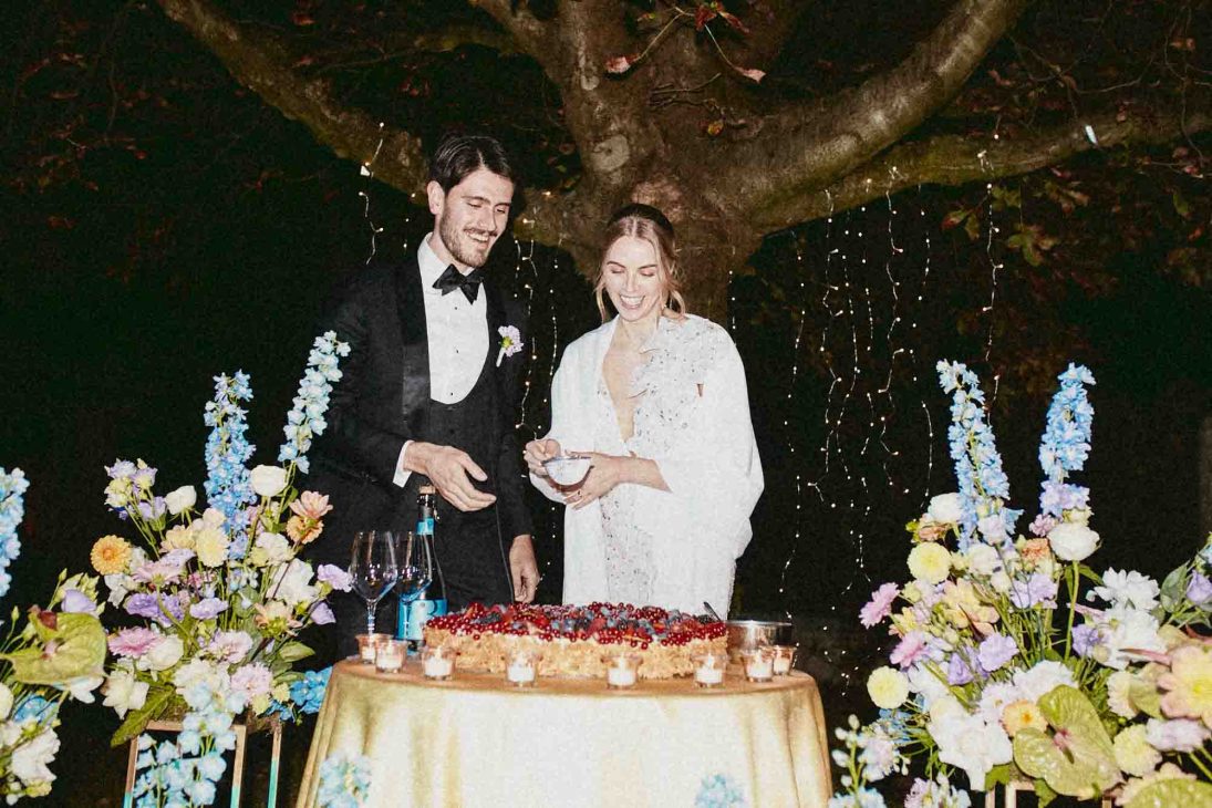 Taglio della torta nuziale serale all'aperto in una villa veneta Vicenza curato da un fotografo matrimonio villa veneta Vicenza.