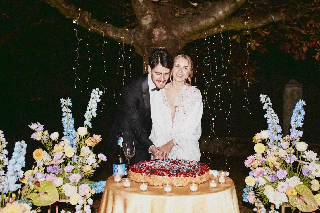 Sposi mentre tagliano la torta nuziale serale all'aperto a cura di un fotografo matrimonio villa veneta Vicenza.