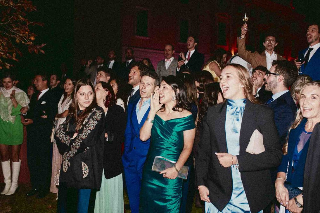 Ospiti festeggiano all'aperto di notte in una storica location curati da un fotografo matrimonio villa veneta Vicenza.